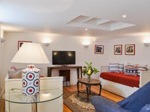 a living room with a bed and a tv at Priory Barn in Weald