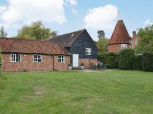 a house with a grass yard in front of it at Priory Barn in Weald