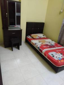 a small bedroom with a bed and a dresser at Raja Homestay Kluang in Kluang