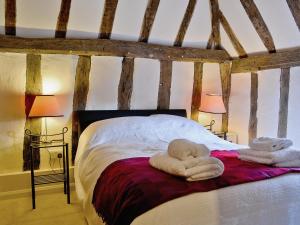 a bedroom with a bed with towels on it at Walnut Cottage in Sproughton