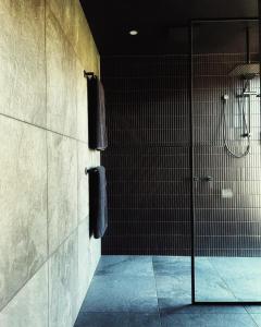 LebrinaにあるMurdoch + Luxury + Experienceのバスルーム(シャワー、黒いタオル付)