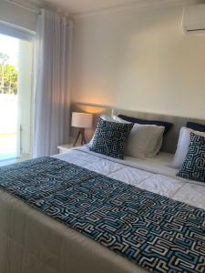 1 dormitorio con 1 cama grande con manta azul y blanca en Casa em Arraial d'Ajuda en Arraial d'Ajuda