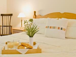 a tray with bread and milk on a bed at Pendre Isaf in Pentre-briwnant