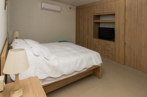 a bedroom with a white bed and a tv at Apartamento acogedor in Montería