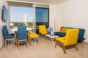 ein Esszimmer mit gelben und blauen Stühlen und einem Tisch in der Unterkunft Apartamento acogedor in Montería