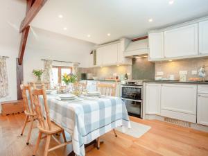 eine Küche mit einem Tisch und Stühlen im Zimmer in der Unterkunft Cowslip Cottage in Templeton