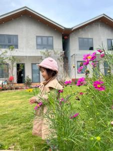 a little girl standing in a field of flowers at Homestay Nhà Hí in Ðinh An (2)