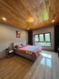 a bedroom with a bed with a wooden ceiling at Homestay Nhà Hí in Ðinh An (2)