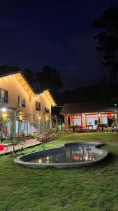 a house with a pool in a yard at night at Homestay Nhà Hí in Ðinh An (2)