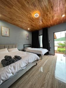 a bedroom with two beds and a wooden ceiling at Homestay Nhà Hí in Ðinh An (2)