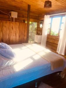 a bedroom with a large bed with a window at Praia de Palmas - Suíte 01 in Governador Celso Ramos