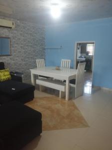 uma mesa branca e cadeiras numa sala de estar em Salama House em Lusaka