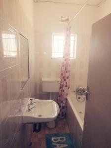 a bathroom with a sink and a toilet and a tub at Salama House in Lusaka