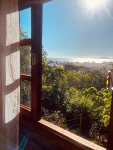 ein offenes Fenster mit Stadtblick in der Unterkunft Recanto da Vila - Suíte 01 in Governador Celso Ramos