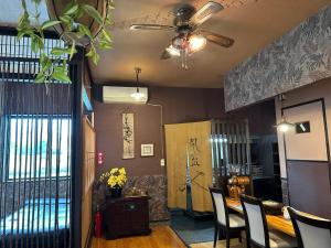 ein Esszimmer mit einem Tisch, Stühlen und einer Decke in der Unterkunft ゲストハウス れんげ苑 in Shimosato