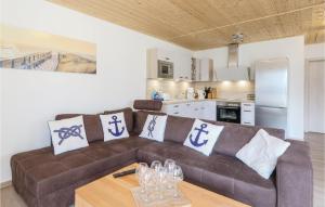 ein Wohnzimmer mit einem braunen Sofa und einer Küche in der Unterkunft Ferienhaus 15 Altefähr in Altefähr + 20 Fotos
