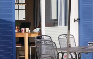 eine Terrasse mit 2 Stühlen und einem Tisch mit einem Schreibtisch in der Unterkunft Ferienhaus 15 Altefähr in Altefähr