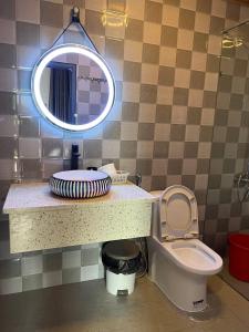 a bathroom with a sink and a toilet and a mirror at Homestay Nhà Hí in Ðinh An (2)