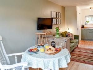 Fuggle في Ludham: غرفة معيشة مع طاولة عليها طعام