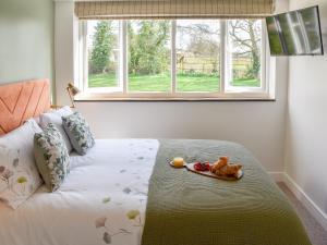 a bedroom with a bed with a plate of food on it at Fuggle in Ludham