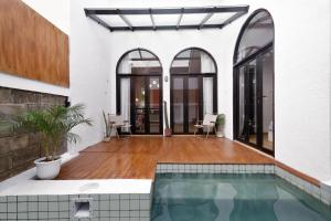 a house with a swimming pool and a patio at Roemah Renjana Rosie Makassar in Makassar
