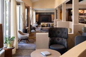 a living room with a chair and a couch at Courtyard by Marriott Fresno in Fresno