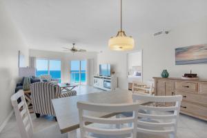 a dining room and living room with a table and chairs at Emerald Isle Unit 1207 in Pensacola Beach