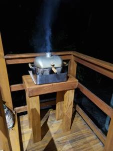 Chalé do Beco - Nova Caraíva في بورتو سيغورو: وعاء جالس على طاولة خشبية مع موقد