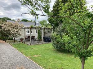 une maison blanche avec un jardin et une pelouse dans l'établissement Country Bliss Cottage, à Greytown