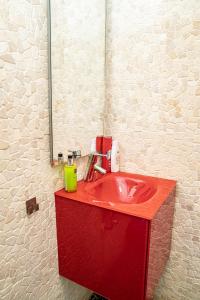 een rode wastafel in een badkamer met een spiegel bij Studio 14 in Braşov
