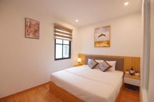 - une chambre avec un lit blanc et une fenêtre dans l'établissement KL HOTEL HA LONG, à Hạ Long