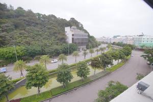 une rue avec des palmiers et une route avec des voitures dans l'établissement KL HOTEL HA LONG, à Hạ Long