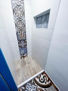 a bathroom with a shower with tiles on the floor at Ancestral Hostel in Bogotá
