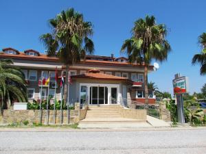 a building with palm trees in front of it at Dalyan Palmiye Resort Hotel in Dalyan