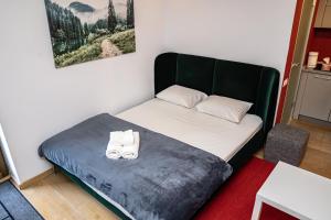 een kleine slaapkamer met een bed met schoenen erop bij Studio 14 in Braşov