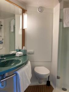 a bathroom with a sink and a toilet and a mirror at ibis Thornleigh in Thornleigh +24 photos