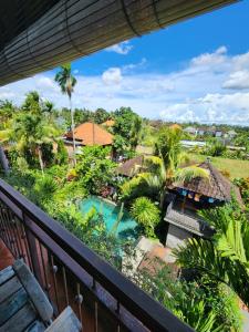 balcone con vista su un resort con piscina di BUDA AMITABA ad Ubud