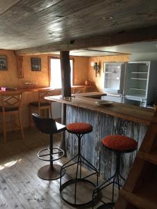 a kitchen with a counter and stools at a bar at Liten stuga mitt i naturen på Kinnekulle in Hällekis