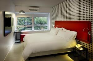 een slaapkamer met een groot bed met een rood hoofdeinde bij Velasco House in Buenos Aires