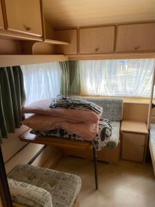 Habitación pequeña con cama y ventana en Camping Erika en Paestum