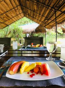 a plate of fruit on a table with a table cloth at Mahoora - Yala by Eco Team in Yala