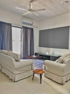 una sala de estar con 2 sofás y una pantalla. en Shah Alam Setia Alam SCCC 3 Storey Semi D 13 Pax, en Shah Alam