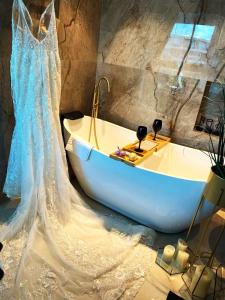 un vestido de novia y una bañera en una habitación en Rose Suite en Caesarea