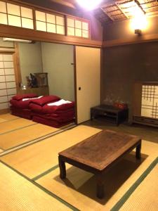 a room with a table and a bed in it at Onomichi Guest House Anago-no-Nedoko in Onomichi