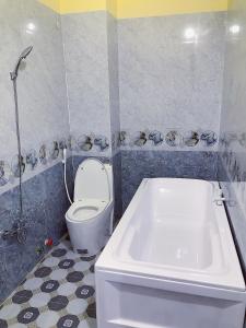 a bathroom with a toilet and a bath tub at Khách sạn Thanh Bình Bến Lức in Bến Lức