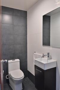 a bathroom with a white toilet and a sink at Palmer Suites in Los Prados