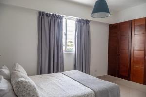 a bedroom with a bed and a window at Palmer Suites in Los Prados