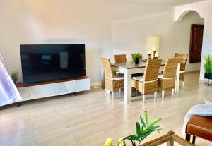 ein Wohnzimmer mit einem Tisch und einem großen TV in der Unterkunft Casa La Ola - Idylle am Meer, La Lajita in Lajita + 18 Fotos