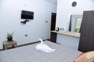 a room with a bed with a white swan on it at LILAC INN in Kodaikānāl