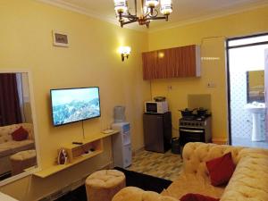 a living room with a couch and a flat screen tv at Denverwing Homes in Eldoret